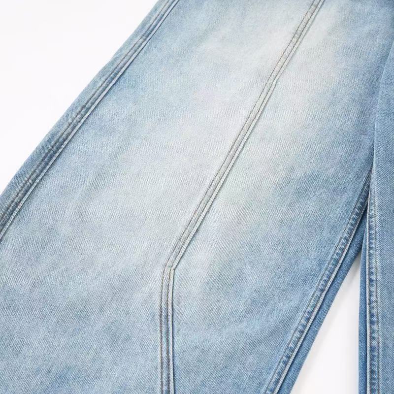 Close-up of light wash jeans leg seam and faded denim texture