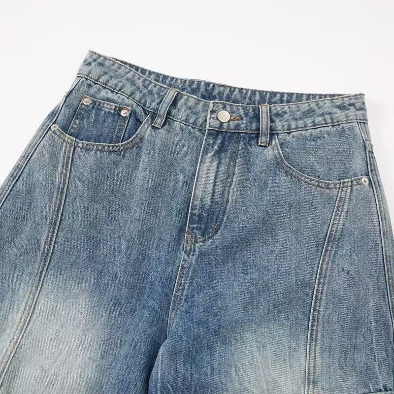 Waistband close-up of light blue denim jeans with front pockets and button closure