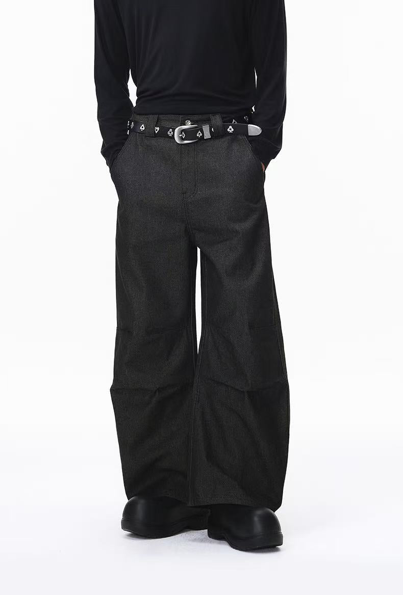 Close-up front view of black wide-leg pants with belt and black shoes
