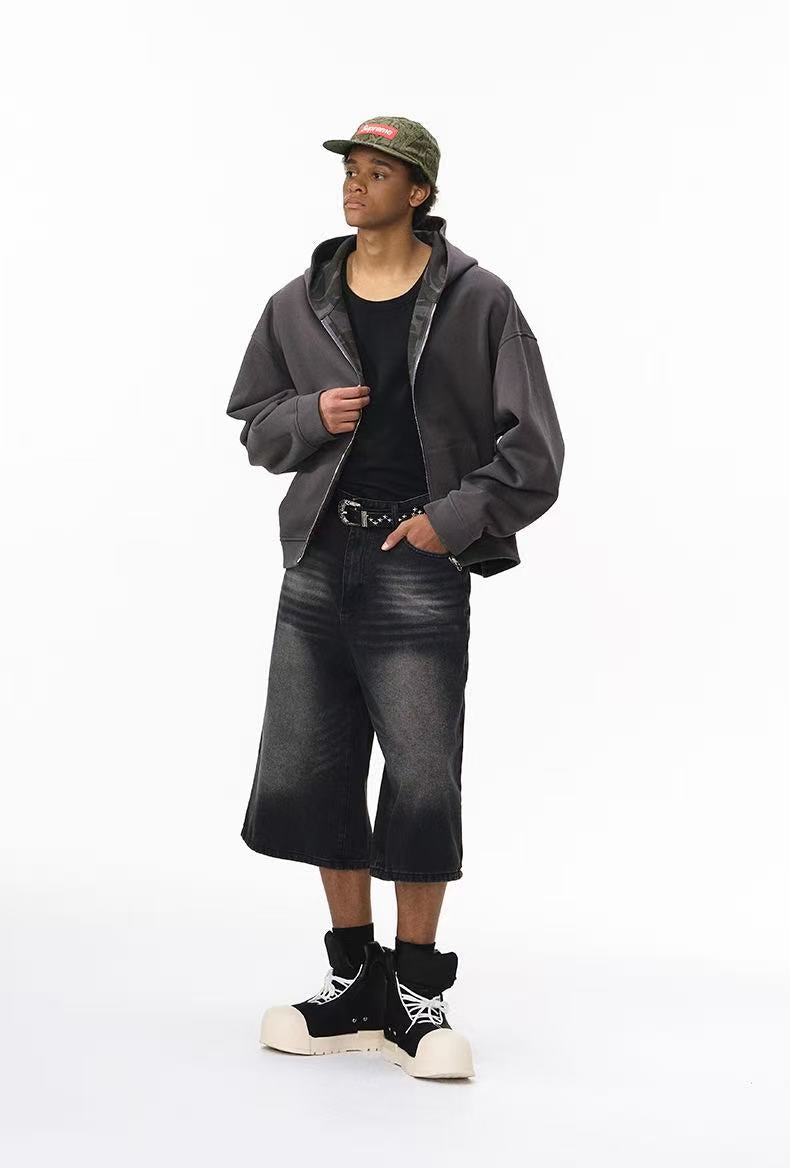 Model in reversible hoodie with solid charcoal body and camo hood lining