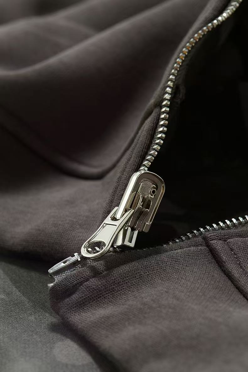 Close-up of metal zipper pull on solid charcoal hoodie