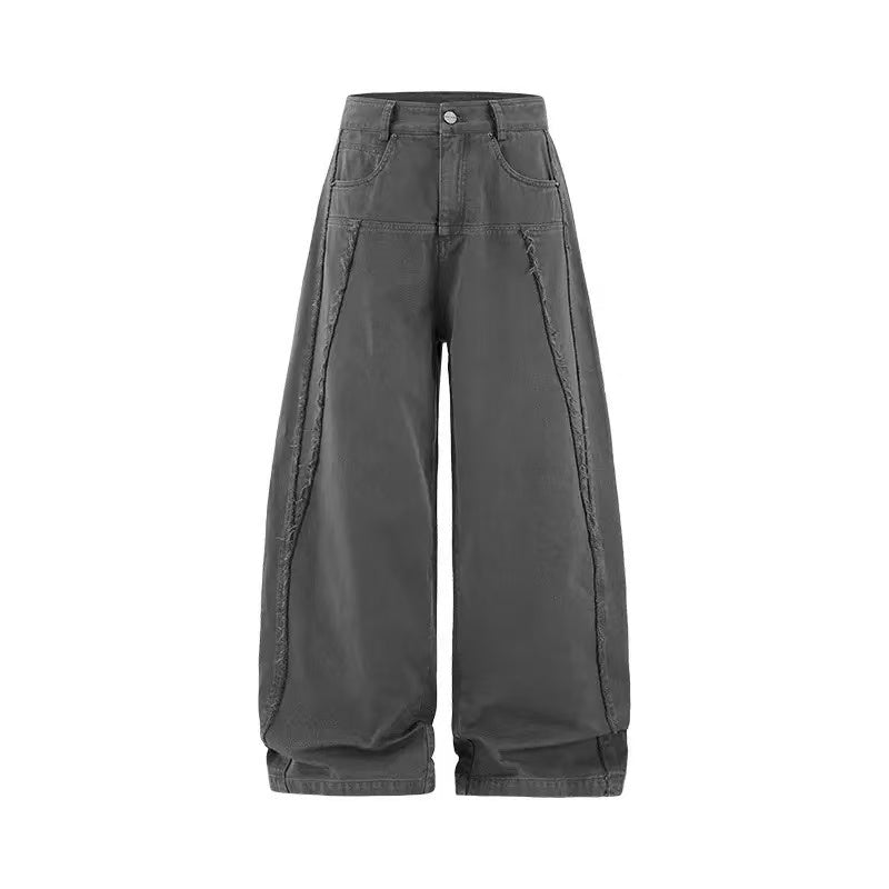 Grey wide-leg cotton pants with raw-edge panel seams and cuffed hem on white background