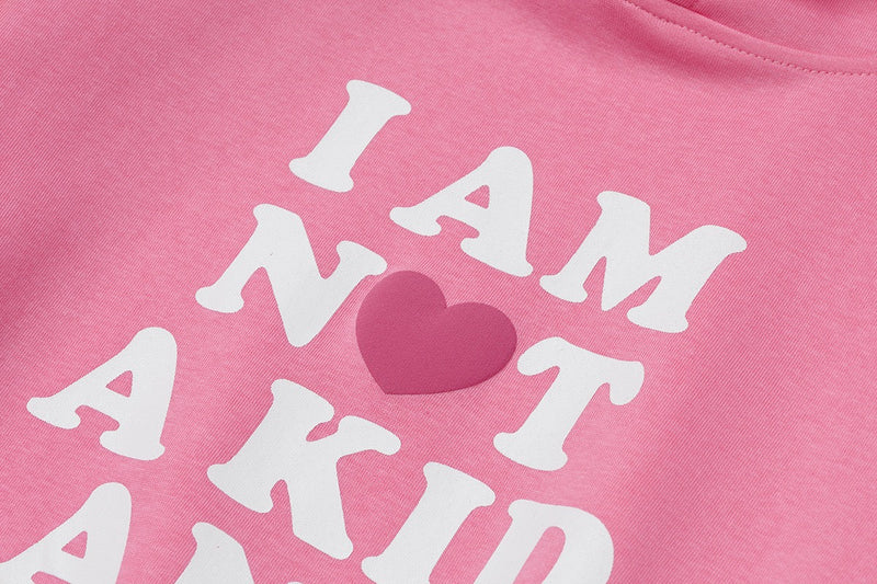 Close-up of pink hoodie chest print with white lettering and heart icon