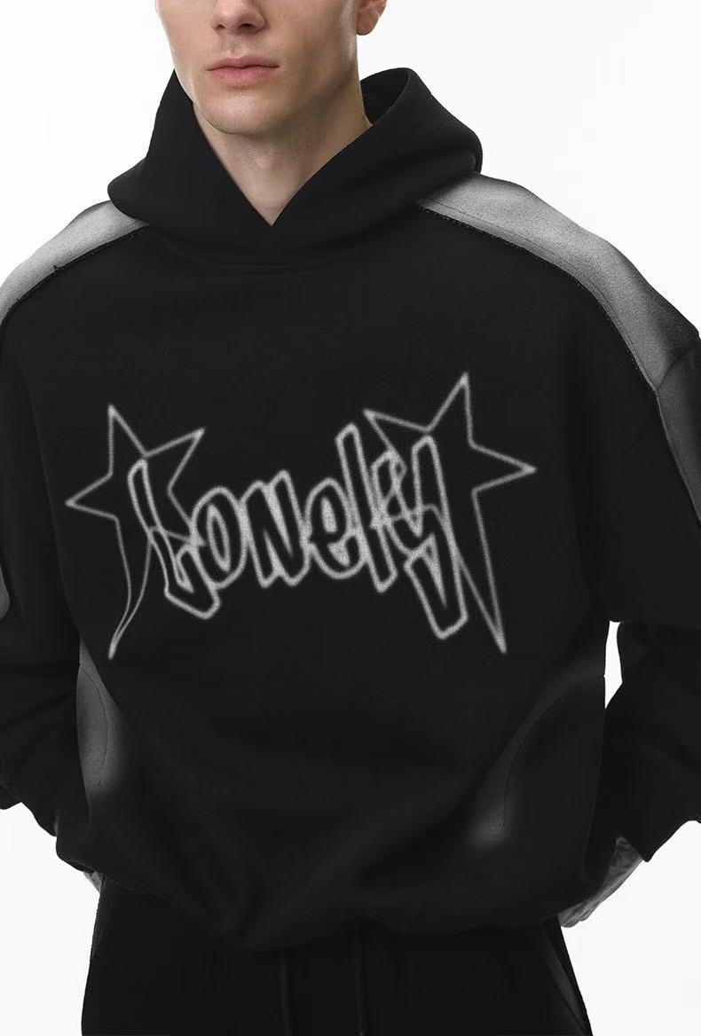Close front view of black cropped hoodie showing star logo print and hood neckline