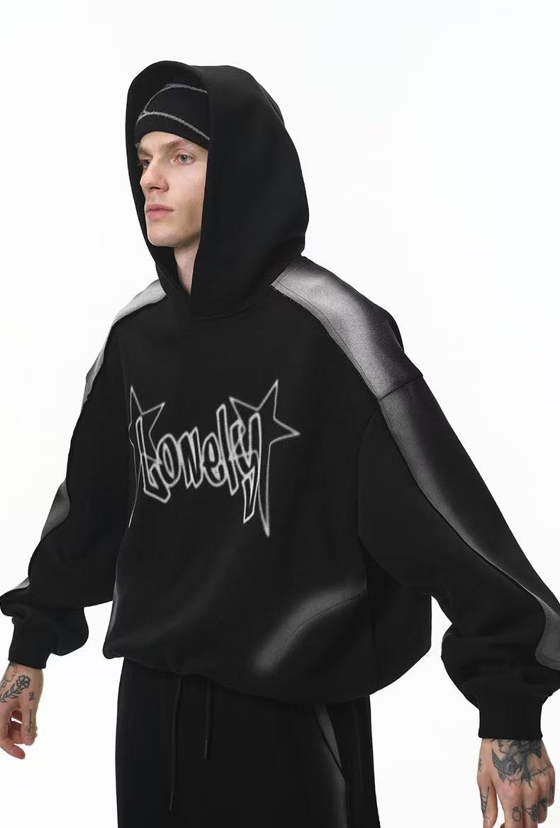 Side view of black cropped hoodie with hood up, gray contrast sleeves, and star logo print