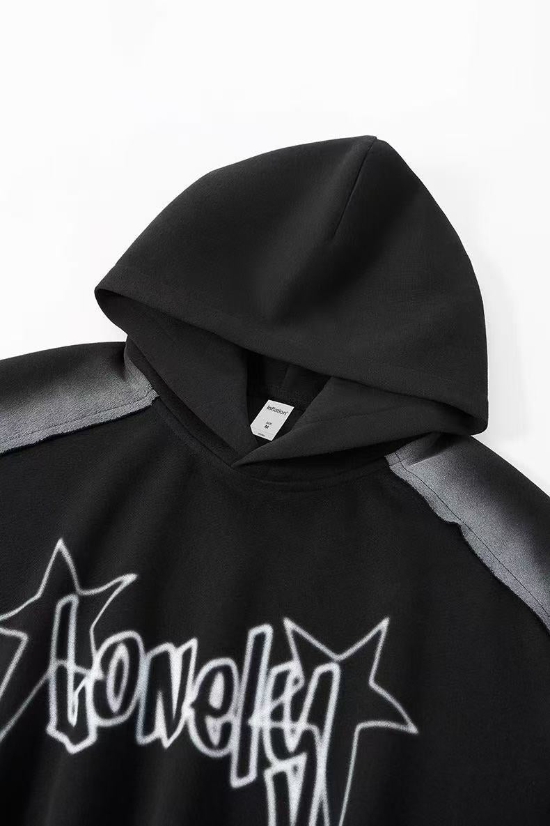 Close-up of black hoodie hood and upper chest with star logo graphic and gray shoulder panel