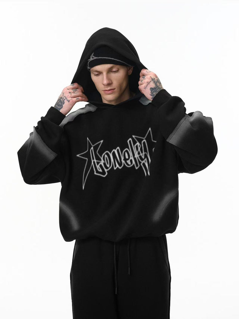 Front view of black cropped hoodie with star logo graphic and gray contrast sleeves on model