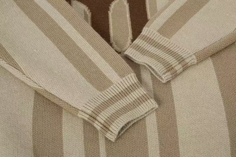 Close-up of the striped sleeve cuffs on a beige knit polo sweater
