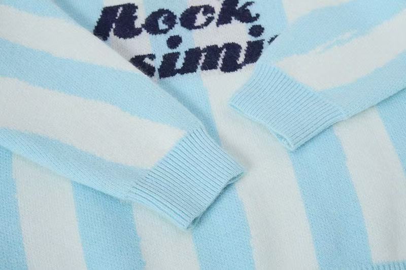 Close-up of sleeve cuffs on light blue striped knit polo sweater