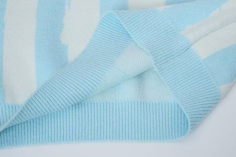 Close-up of folded ribbed cuff and hem on light blue striped knit sweater