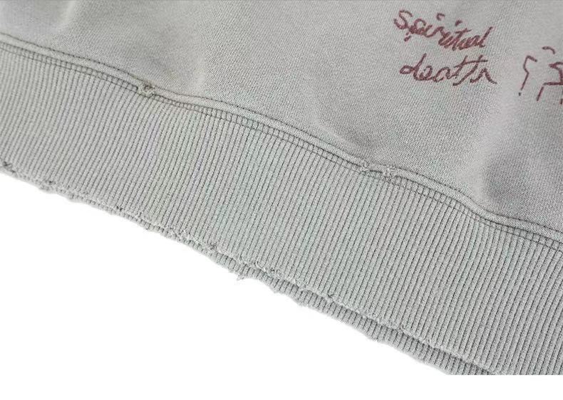 Light gray sweatshirt hem with ribbed knit trim and handwritten graphic detail