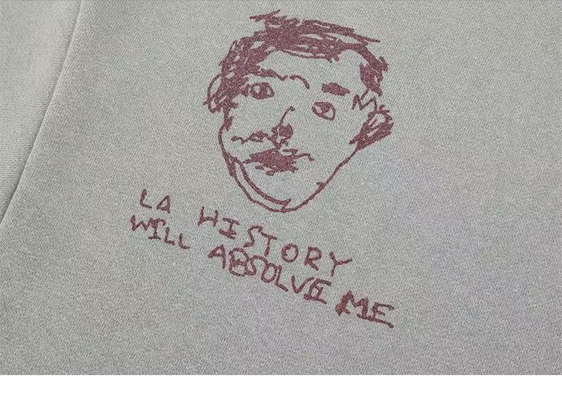Close-up of a sketched face and handwritten text on the light gray sweatshirt back