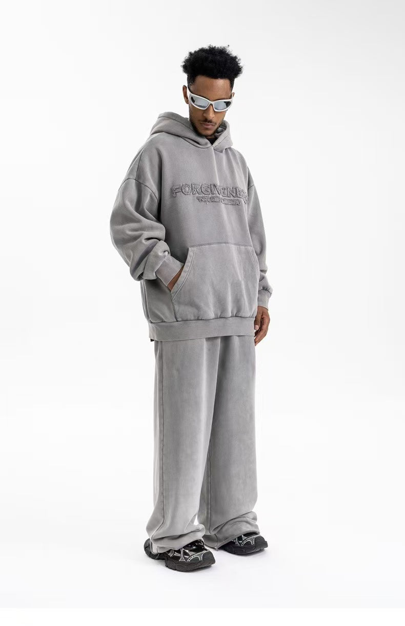 Full-length side view of taupe oversized hoodie with embroidered chest detail and matching pants