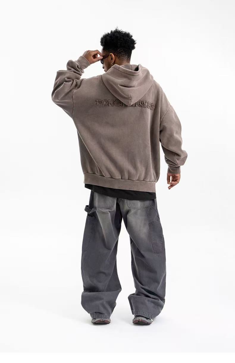 Back view of brown-gray oversized hoodie with hood and upper-back Forgiveness embroidery