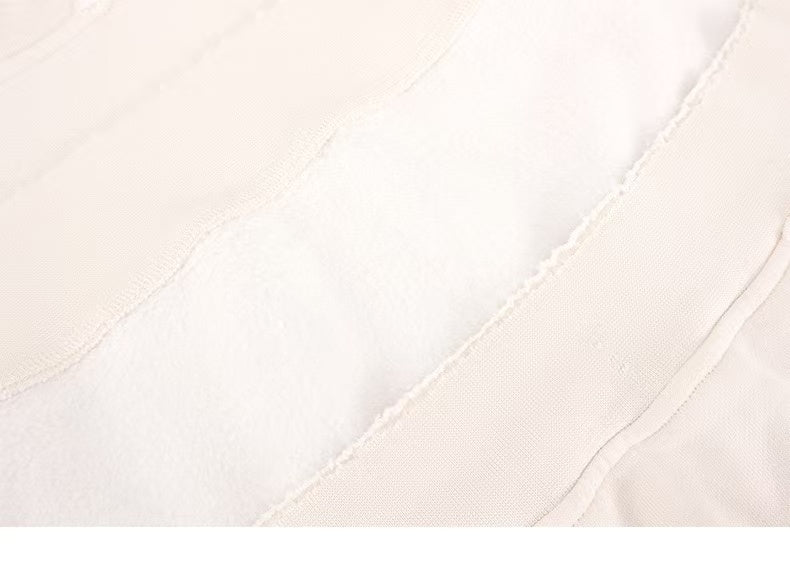 Close-up of cream sweatshirt fabric and seam lines with distressed texture