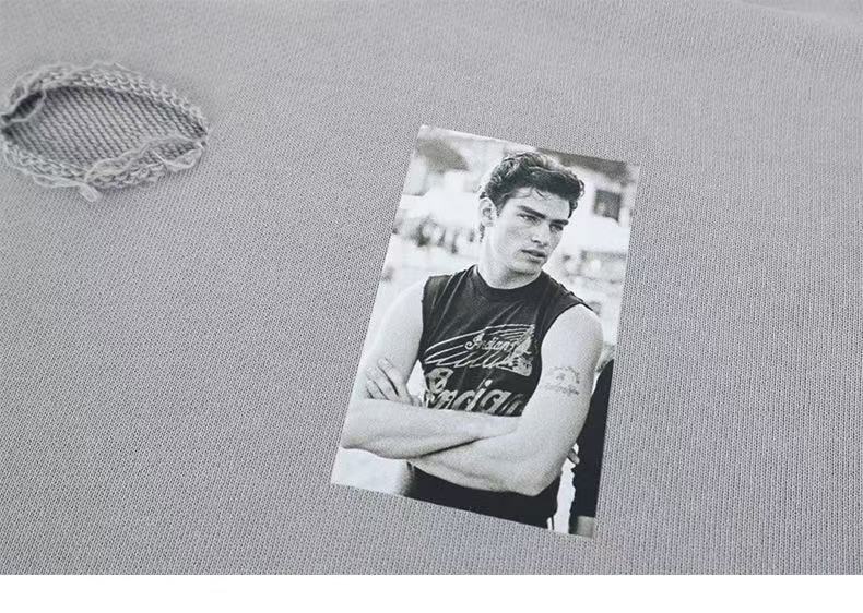 Close-up of gray hoodie chest with a black-and-white photo patch and ripped detail