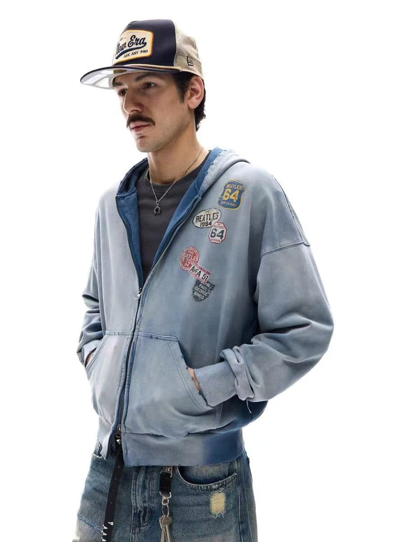 Side view of model wearing washed blue zip-up hoodie with patch graphics and ribbed hem