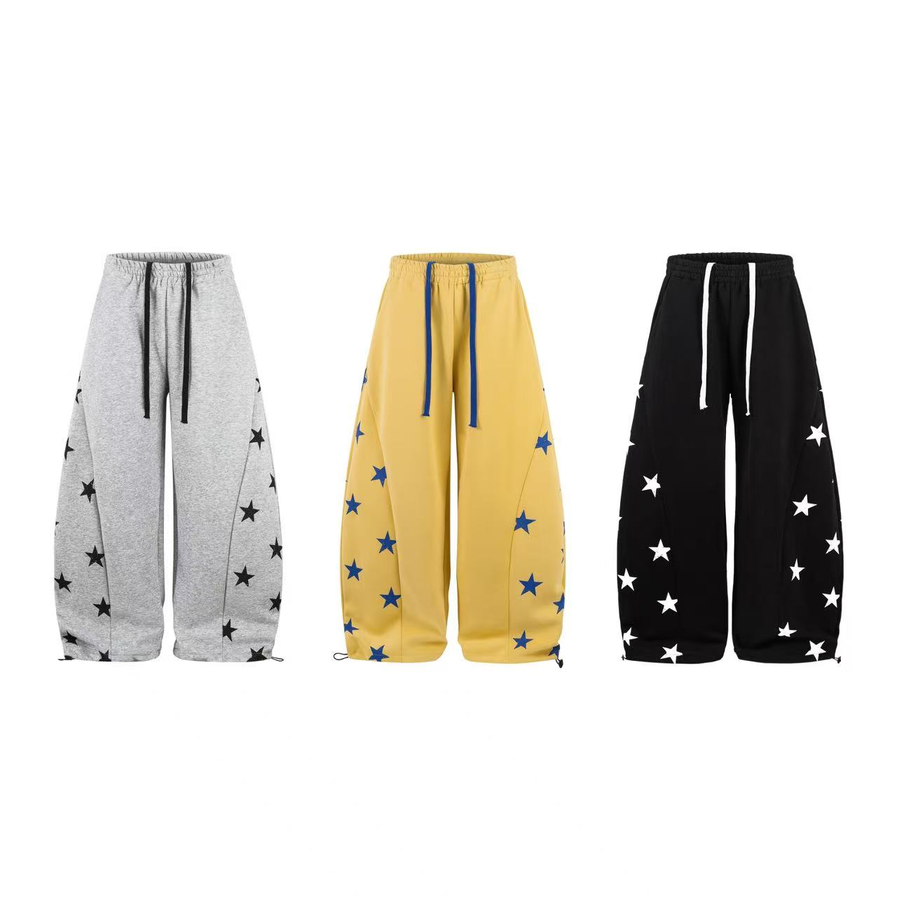 Yellow wide-leg sweatpants with blue star print, blue drawstring waist, and cinched ankle hems on white background