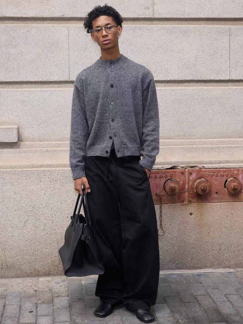Gray button-up cardigan worn with black pants, front view