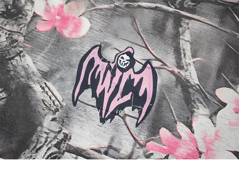 Gray camo hoodie chest graphic with pink bat-style logo and blossoms