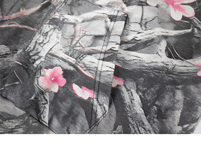 Front kangaroo pocket on gray camo hoodie with pink blossom print