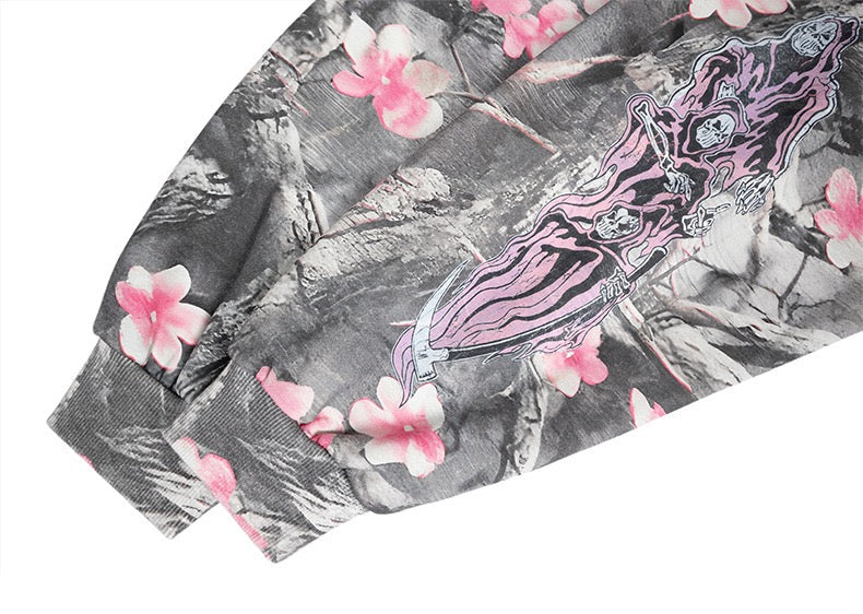 Sleeve cuff on gray camo hoodie with pink skeleton graphic and blossoms