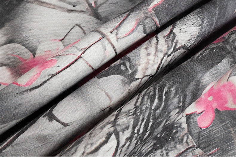 Folded gray camo hoodie fabric with pink cherry blossom pattern
