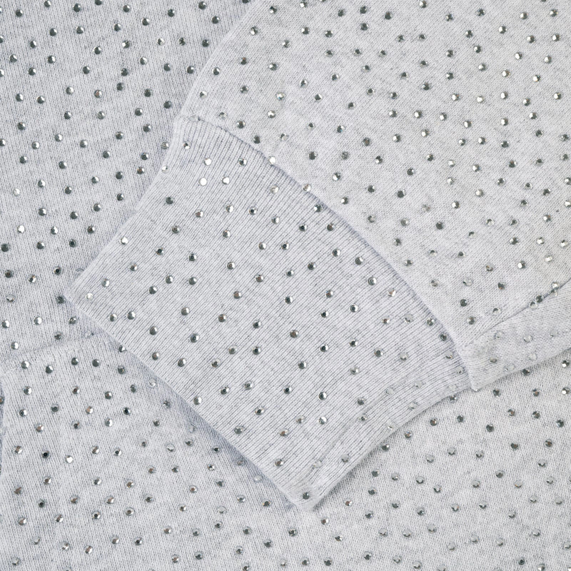 Close-up of the Grey Sp5der Rhinestone VVS Hoodie 440GSM, featuring light gray knit fabric with ribbed cuffs and evenly placed shiny silver rhinestones for a subtle, elegant pattern.