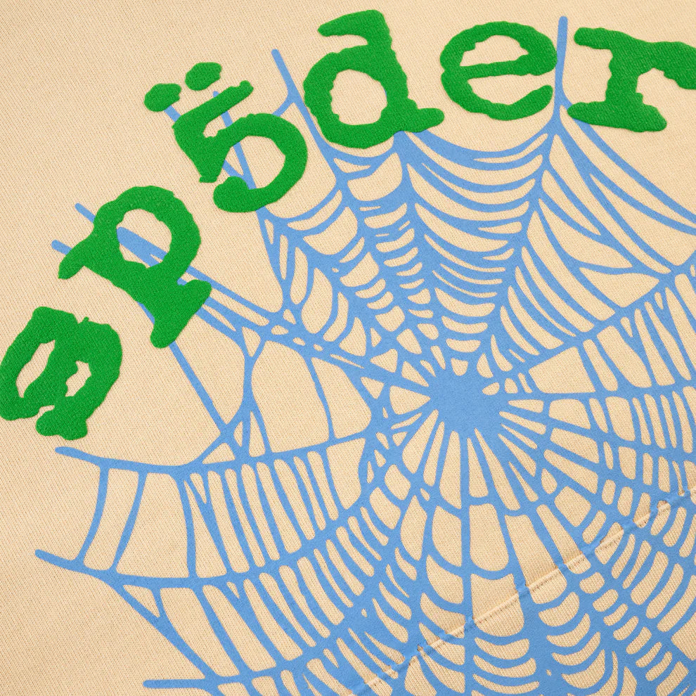 A bold blue spider web on beige with "spōder" in green, inspired by Y2K street style and the Sp5der “Sky Web” Hoodie – Cream / Blue / Green 440GSM Oversized Streetwear Pullover’s striking aesthetic.