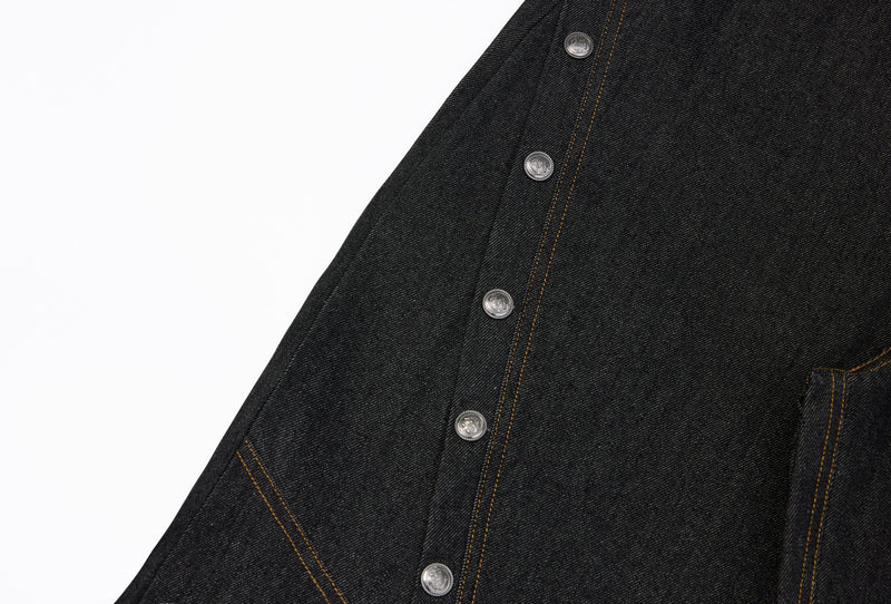 Side close-up of dark denim jeans with silver snap buttons and stitched panel seam