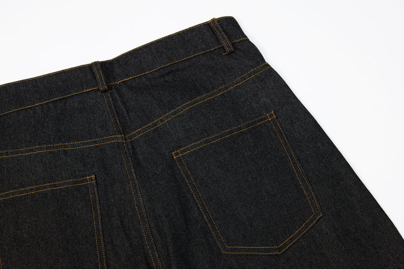 Back waist close-up of dark wide-leg jeans showing rear pockets and contrast stitching
