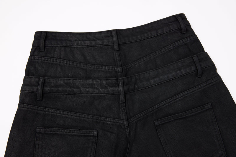 Back waist close-up of black wide-leg jeans with layered waistband and back pockets
