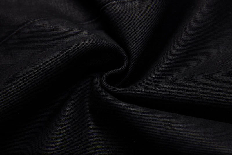 Close-up of black denim fabric texture with soft folded weave
