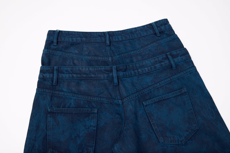 Back waist close-up of dark blue washed jeans with layered waistband and pockets
