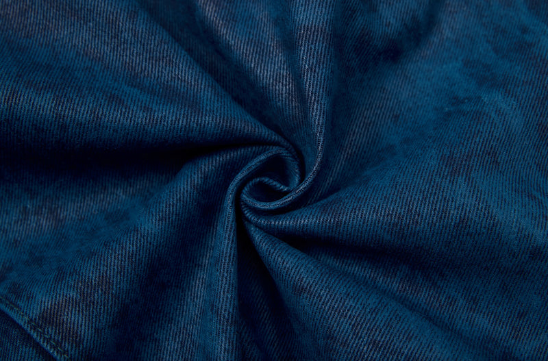 Close-up of dark blue denim fabric texture with a twisted fold