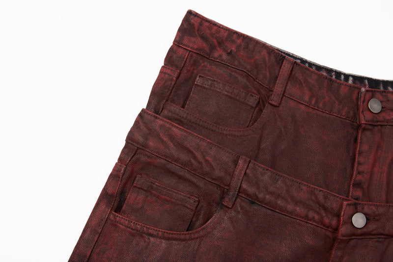Close-up of the front right waist on burgundy washed jeans with layered waistband and snap button