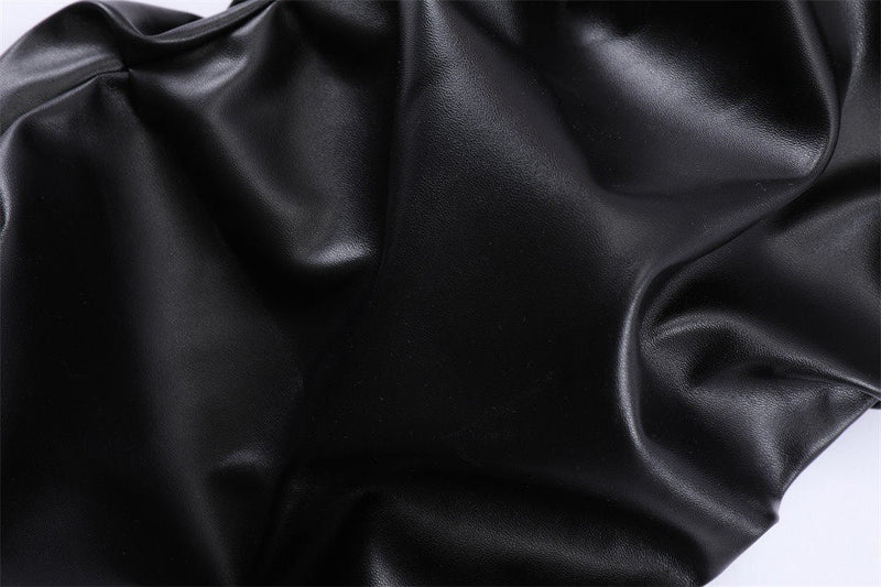 Close-up of black faux leather with a smooth shiny texture and soft creases