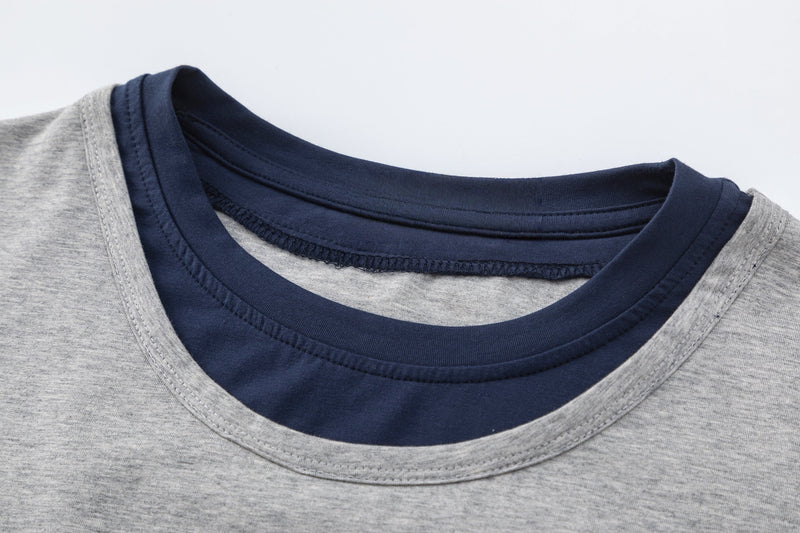 Close-up of a gray colorblock raglan T-shirt with navy contrast neckline and layered hem detail