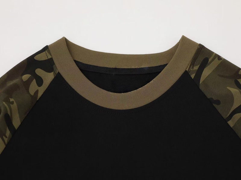 Close-up of crew neck on black raglan tee with olive rib trim and camouflage shoulders