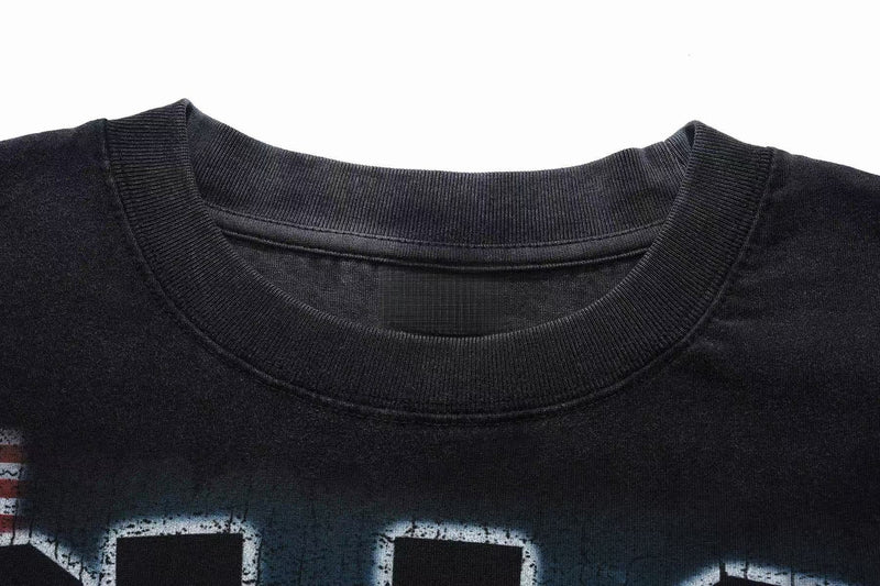 Close-up of a black vintage washed oversized graphic tee with ribbed crew neck and distressed print details