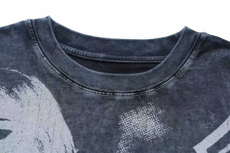 Close-up of a vintage washed gothic graphic T-shirt with ribbed crew neck and distressed black and gray print detail