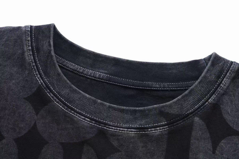 Close-up of a vintage washed black gothic T-shirt with ribbed crew neckline and contrast stitching detail