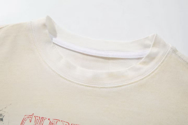 Cream graphic tee with red retro collage print and ribbed crew neckline on a white background