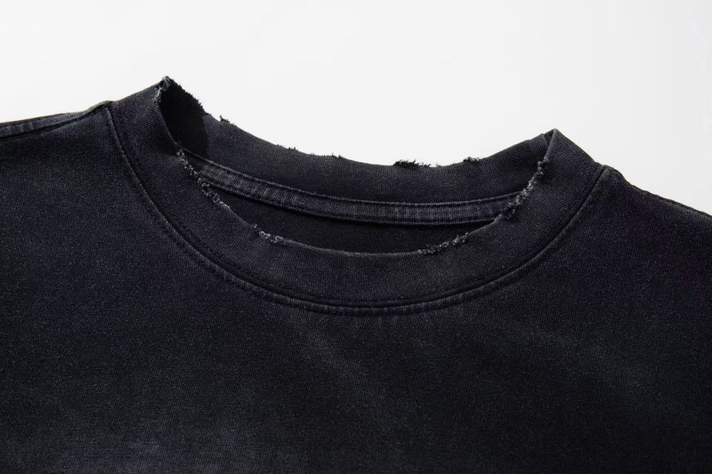 Black washed graphic tee with distressed raw-edge collar and vintage faded finish
