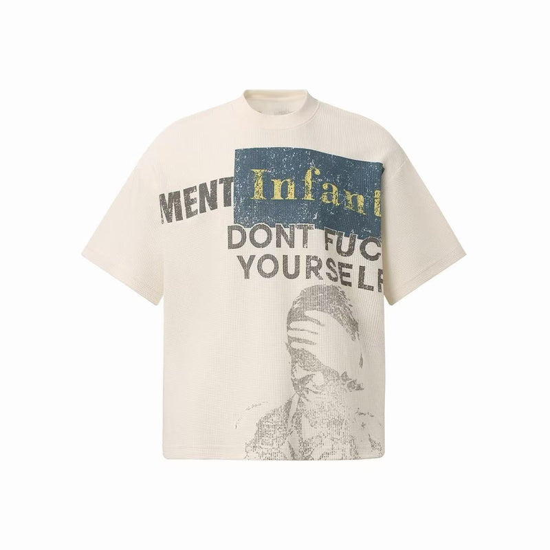 Cream waffle knit tee with distressed graphic print, bold text, and oversized streetwear silhouette