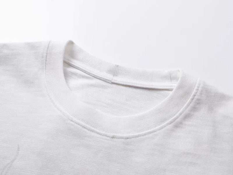 Close-up of white crewneck collar on long sleeve tee