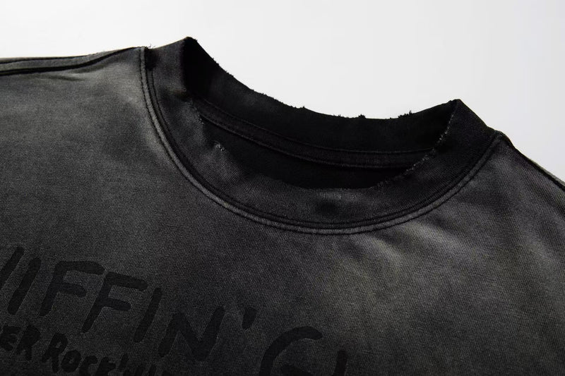Black washed graphic T-shirt with faded punk zine lettering and raw-cut distressed crew neckline