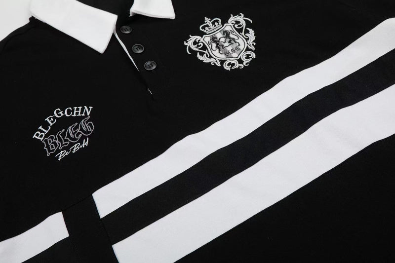 Black and white striped men’s polo shirt with embroidered crest, button placket, and contrast collar details