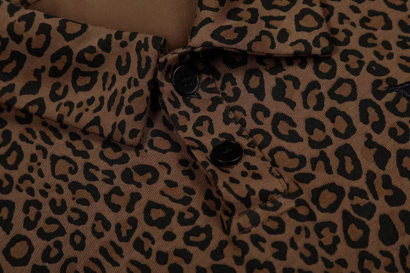 Close-up of a brown leopard print polo tee with black buttons and collar detail
