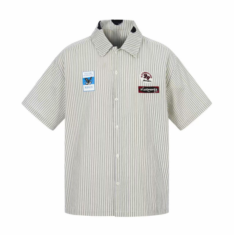 Short-sleeve pinstripe button-up shirt with patch graphics and streetwear collar details on white background
